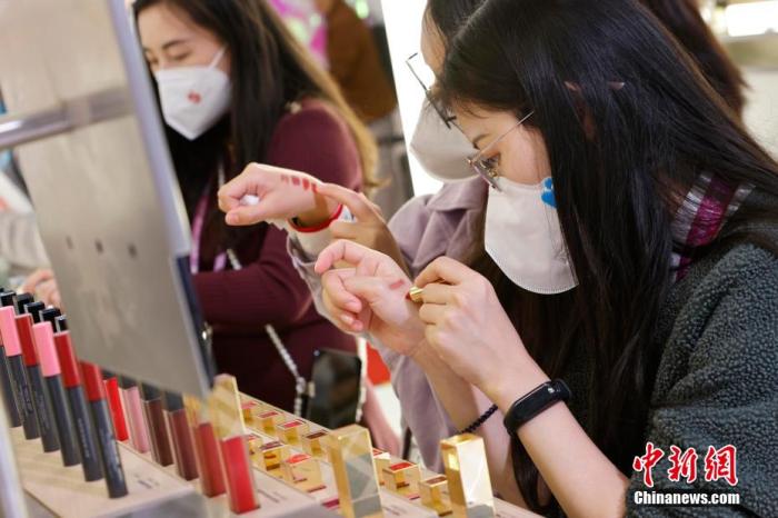 圖為女生正在體驗口紅產(chǎn)品。 殷立勤 攝