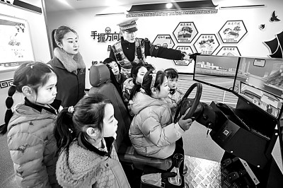 山東省榮成市公安局道路交通安全宣傳教育基地，交警帶領(lǐng)小學(xué)生現(xiàn)場體驗(yàn)?zāi)M駕駛。新華社發(fā)