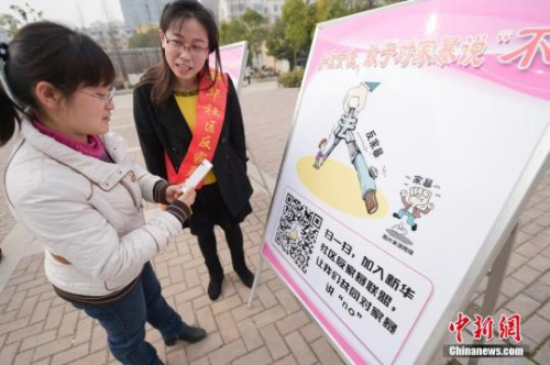 資料圖：今年3月8日，安徽合肥新華社區(qū)志愿者夏一瓊(右)向市民普及反家暴相關(guān)法律知識。鐘欣 攝