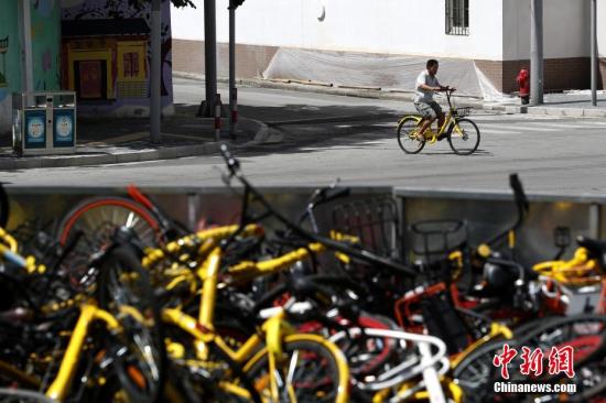 上?,F(xiàn)共享單車“墳?zāi)埂?堆積如山場(chǎng)面壯觀。 張亨偉 攝